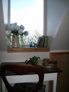 a table with a vase of flowers next to a window at Highland Park House in Kirkwall