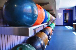 eine Reihe von Bowlingkugeln auf einer Kegelbahn in der Unterkunft Hotel Landhus in Zürich