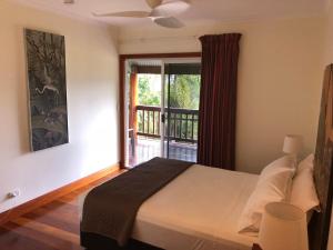 a bedroom with a bed and a window with a balcony at Daintree Manor B&B in Daintree