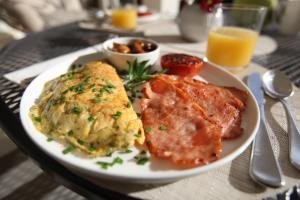 a plate of food with meat and eggs on a table at The Ridge Retreat at Mollymook in Mollymook