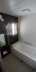 ein kleines Zimmer mit einem Bett und einem Fenster in der Unterkunft Hakuba Powder Cottage Crystal in Hakuba