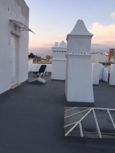 a balcony with white furniture on a roof at Casa Tradicional Algarvia - Rooms in Faro