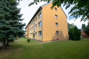 ein großes gelbes Gebäude mit einem Rasenplatz in der Unterkunft Big 1 Room Apartment - 15 Min Messe DUS in Meerbusch