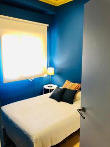 een slaapkamer met blauwe muren en een bed met 2 kussens bij Ritual Sevilla Suite Alameda 5 in Sevilla