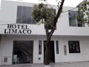 a hotel limico building with a tree in front of it at Hotel Limaco in Neiva