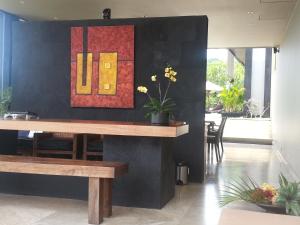a dining room with a table and a painting on the wall at The Puncak Lombok in Senggigi