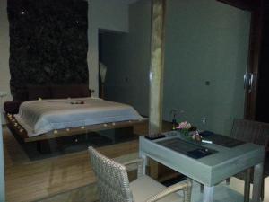 a bedroom with a bed and a table and chairs at The Puncak Lombok in Senggigi