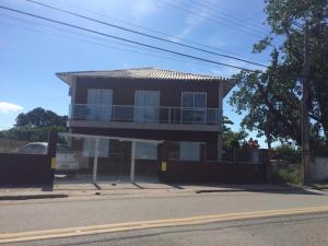une maison avec un balcon sur le côté de la rue dans l'établissement Recanto aconchegante no Campeche Apart 05 - 50m da praia -, à Florianópolis