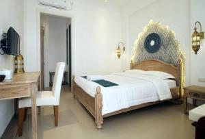 a bedroom with a bed and a table and a desk at Rumah Jawa Guest House (Syariah) in Yogyakarta