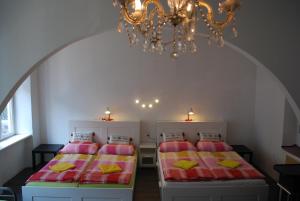 two beds in a room with a chandelier at FEWO Pazmaniten in Vienna