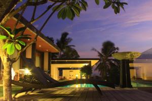 a resort with a hammock in front of a house at The Puncak Lombok in Senggigi