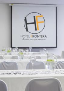a set of tables with white chairs and a screen at Hotel Frontera Clásico in Temuco