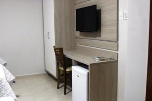 a small room with a desk and a tv in it at Hotel San Remo in Jequié