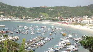 Un montón de barcos están atracados en una playa en Apartamento Arraial Do Cabo, en Arraial do Cabo