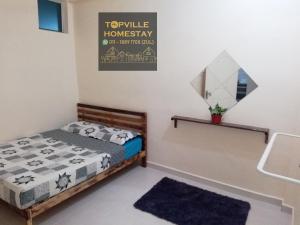 a bedroom with a bed and a mirror on the wall at Topville Homestay in Kangar