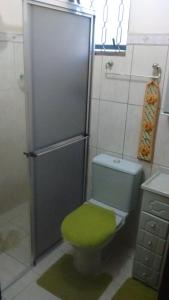 baño con aseo y taburete verde en POUSADA FAMILIAR S.R., en São Gabriel