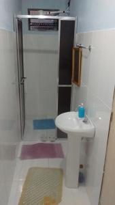 a small bathroom with a sink and a shower at POUSADA FAMILIAR S.R. in São Gabriel