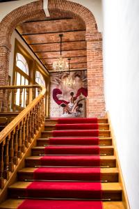 a red carpet staircase in a building with a chandelier at Casa San Jacinto in Mexico City