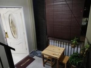 a small wooden table in front of a door at Topville Homestay in Kangar