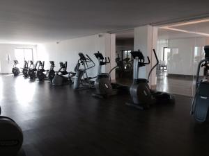 a gym with a row of treadms and elliptical machines at La Isla Gran Cayman 904 in Acapulco