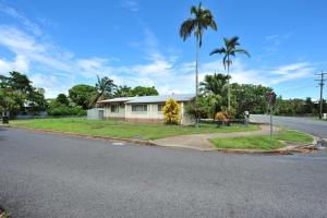 a house on the side of a street with palm trees at Seascape Holidays - 53 Reef Street in Port Douglas