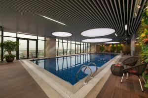 a swimming pool in a building with windows at Ha Long Marina Hotel in Ha Long
