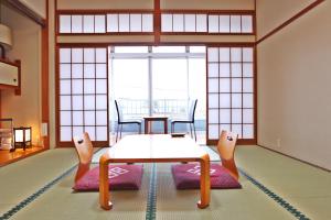ein Wohnzimmer mit einem Tisch und Stühlen im Zimmer in der Unterkunft Ebisusou in Takashima