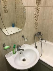 a bathroom with a sink and a mirror and a tub at Apartment on Amurskiy Bulvar 62 in Khabarovsk
