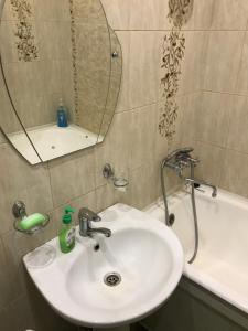 e bagno con lavandino, specchio e vasca. di Apartment on Amurskiy Bulvar 62 a Khabarovsk