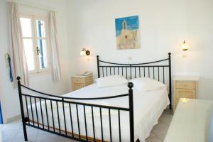 sypialnia z czarnym łóżkiem z białą pościelą w obiekcie Blue Bay Villas w mieście Kamari