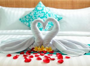 two swans made out of towels on a bed at Anja Jimbaran in Jimbaran