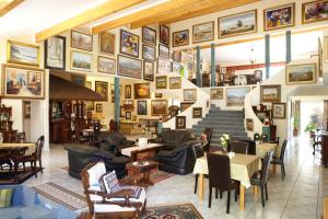 a lobby with chairs and tables and pictures on the wall at 7 Eland Boutique Guest House in Ladismith