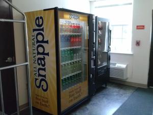 a soda machine with a box in a room at Best Studio Inn Homestead (Extended Stay) in Homestead