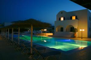 basen z leżakami i parasolami w nocy w obiekcie Blue Bay Villas w mieście Kamari +16 zdjęć