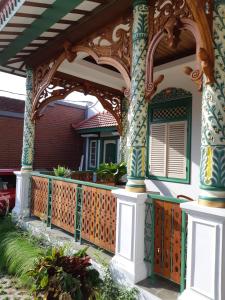 a porch of a house with a wooden fence at Rumah Jawa Guest House (Syariah) in Yogyakarta