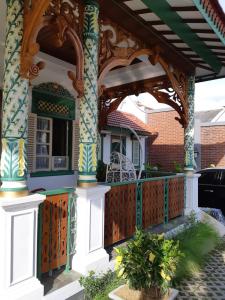 uma casa com um alpendre com uma cerca de madeira em Rumah Jawa Guest House (Syariah) em Yogyakarta