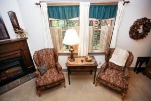 uma sala de estar com 2 cadeiras, uma mesa e uma lareira em Watson Estate BnB & Deer Creek Winery em Uniontown
