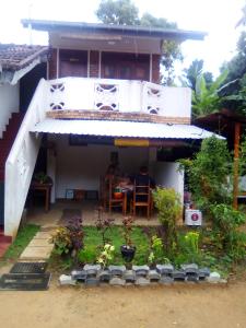 a house with a porch with a table in it at Jayanika home stay in Tangalle