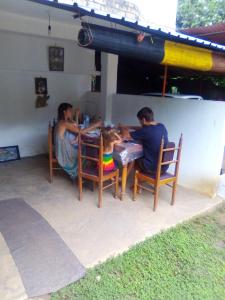 un grupo de personas sentadas en una mesa en Jayanika home stay, en Tangalle