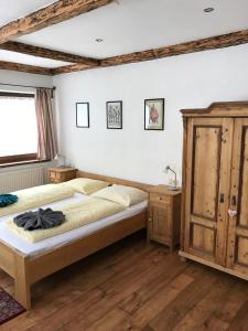 - une chambre avec un lit et une armoire en bois dans l'établissement Tuxie Haus, à Tux