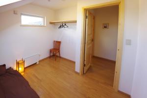 a room with a bed and a window and a door at Niseko Guesthouse Nalu. in Niseko
