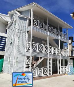 un gran edificio de apartamentos con balcones y un cartel delante en Posada Smith Town, en San Andrés
