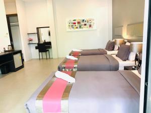 ein Hotelzimmer mit 2 Betten und einem Sofa in der Unterkunft Tandeaw View in Hua Hin