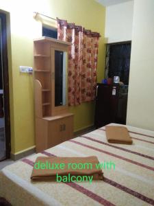 a bedroom with a bed with a dresser and a mirror at Casa De Olga in Vagator