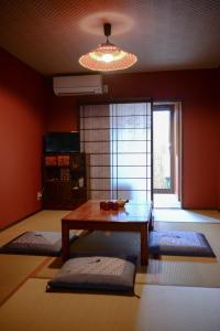 a living room with a table and a window at Nishioji KADO 西大路 角 わんちゃんと泊まれるお宿 in Kyoto