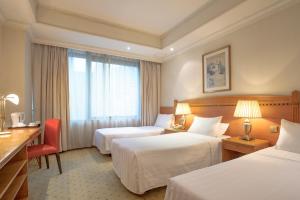 Habitación de hotel con 2 camas y escritorio en BEST WESTERN PLUS Hotel Hong Kong en Hong Kong