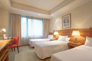 香港にあるBEST WESTERN PLUS Hotel Hong Kongのベッド2台と机があるホテルの部屋