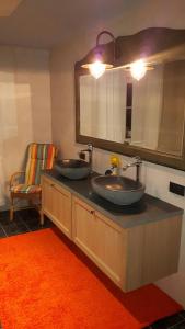 マースメヘレンにあるHemelse Helderheidのバスルーム(シンク2台、鏡、オレンジの敷物付)