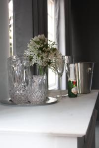 a counter with glasses and a vase of flowers on it at Arum Lily Guest Rooms in Pretoria