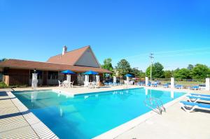 a large swimming pool with blue water in front of a building at Days Inn & Suites by Wyndham Colonial in Williamsburg